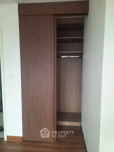 Spacious wooden wardrobe with sliding doors in modern interior