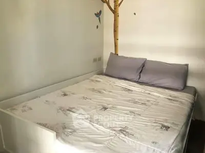 Cozy bedroom with unique tree wall art and comfortable bedding, perfect for relaxation.