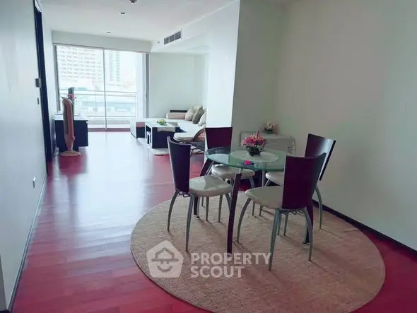 Spacious living room with dining area and large windows offering city views.