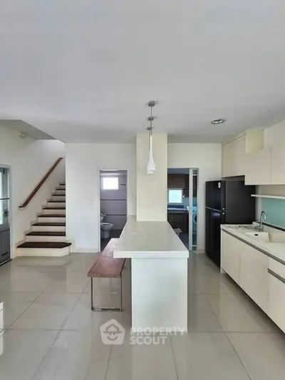 Modern kitchen with sleek design and open layout, featuring a central island and minimalist cabinetry.