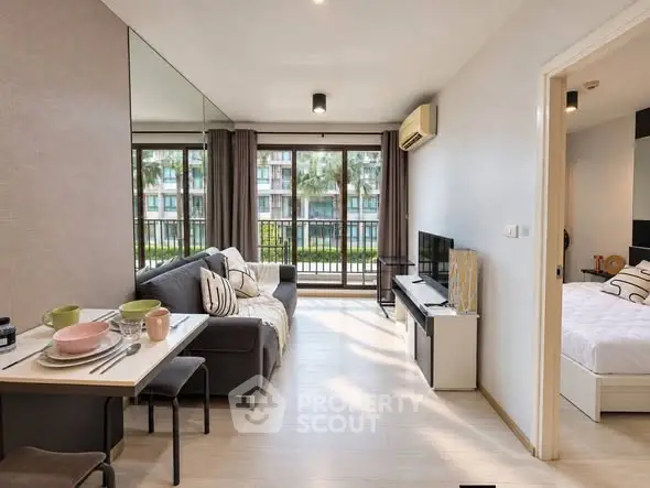 Modern living room with dining area and view of bedroom, featuring stylish decor and natural light.