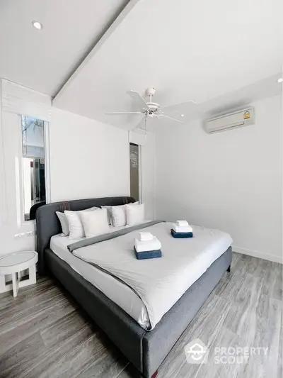 Modern bedroom with stylish decor, featuring a comfortable bed and air conditioning.