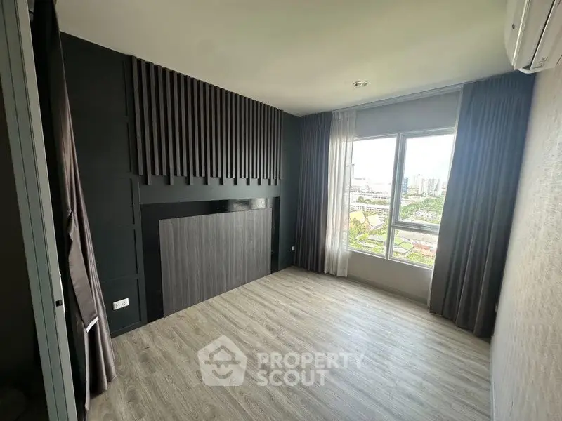 Modern empty room with large window and city view, featuring sleek flooring and stylish wall design.