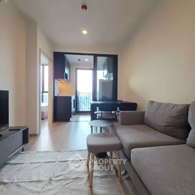 Modern living room with cozy sofa and open kitchen layout in a stylish apartment.