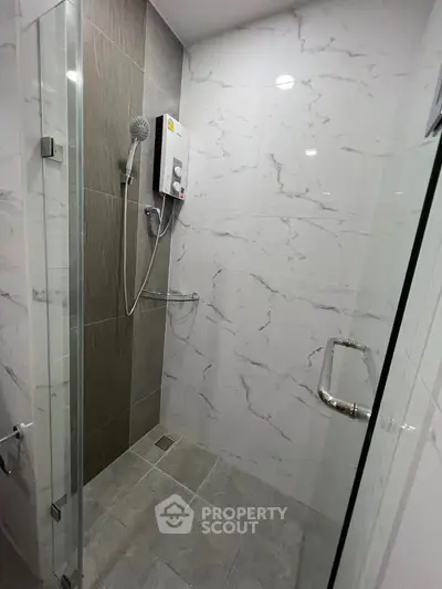 Modern bathroom with sleek shower and marble tiles, perfect for a contemporary home.