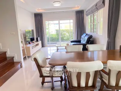 Spacious living and dining area with elegant furniture and large windows for natural light.