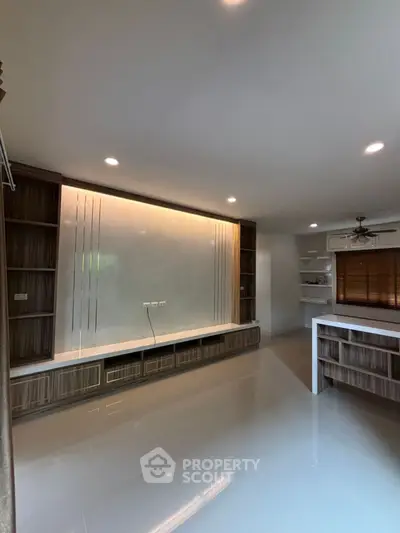 Spacious modern living room with sleek built-in shelving and glossy floors
