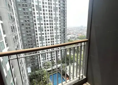 High-rise apartment balcony with cityscape and pool view, perfect for urban living.