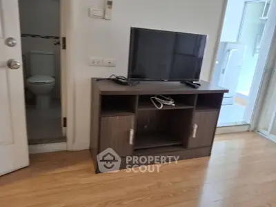 Compact living room with TV stand and adjacent bathroom in modern apartment