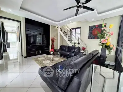 Luxurious modern living room with sleek black leather sofas and stylish decor, perfect for contemporary living.