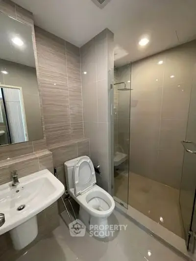 Modern bathroom with sleek design, featuring a glass shower and contemporary fixtures.