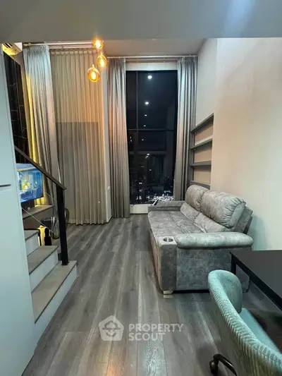 Modern living room with high ceilings, stylish lighting, and a cozy sofa in a chic apartment.