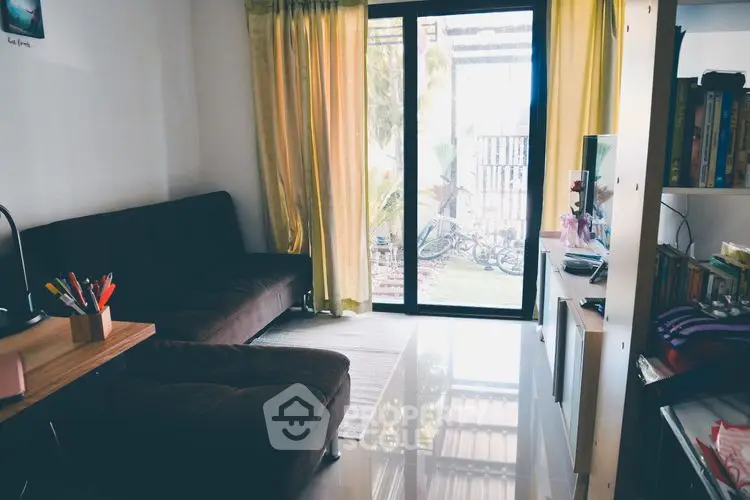 Cozy living room with garden view and natural light, featuring a comfortable sofa and modern decor.