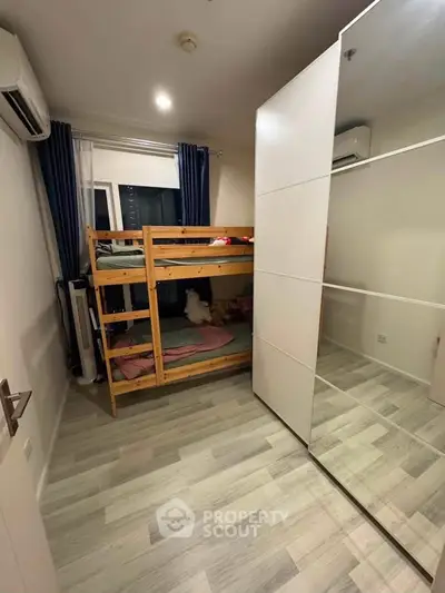 Cozy bedroom with bunk bed and mirrored wardrobe, perfect for maximizing space in modern apartments.