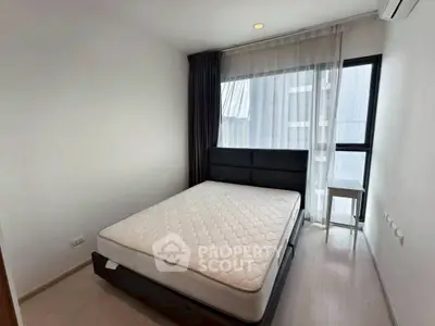 Modern minimalist bedroom with large window and stylish bed in a high-rise apartment.