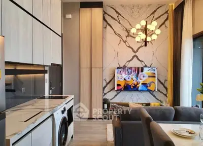 Modern living room with stylish kitchen and marble accent wall, featuring a washing machine and elegant lighting.