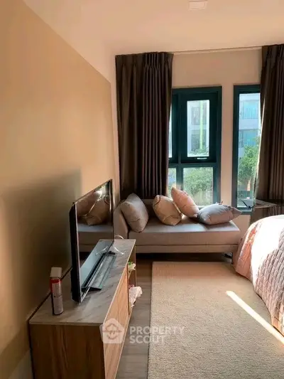 Cozy bedroom with modern decor and large windows offering natural light.