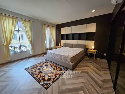 Spacious modern bedroom with elegant decor and large windows for natural light.
