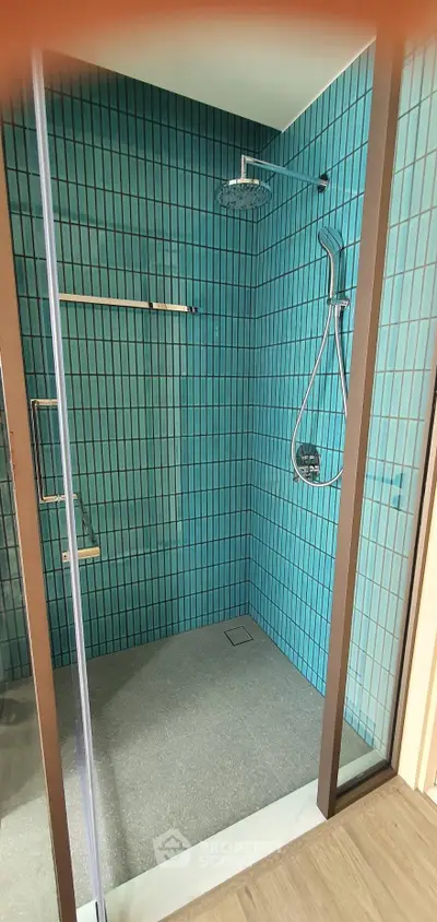 Modern bathroom with vibrant teal tiles and sleek shower design