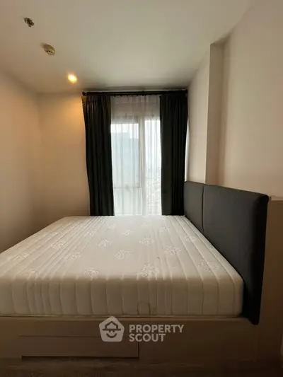 Cozy bedroom with large window and modern decor in a stylish apartment.