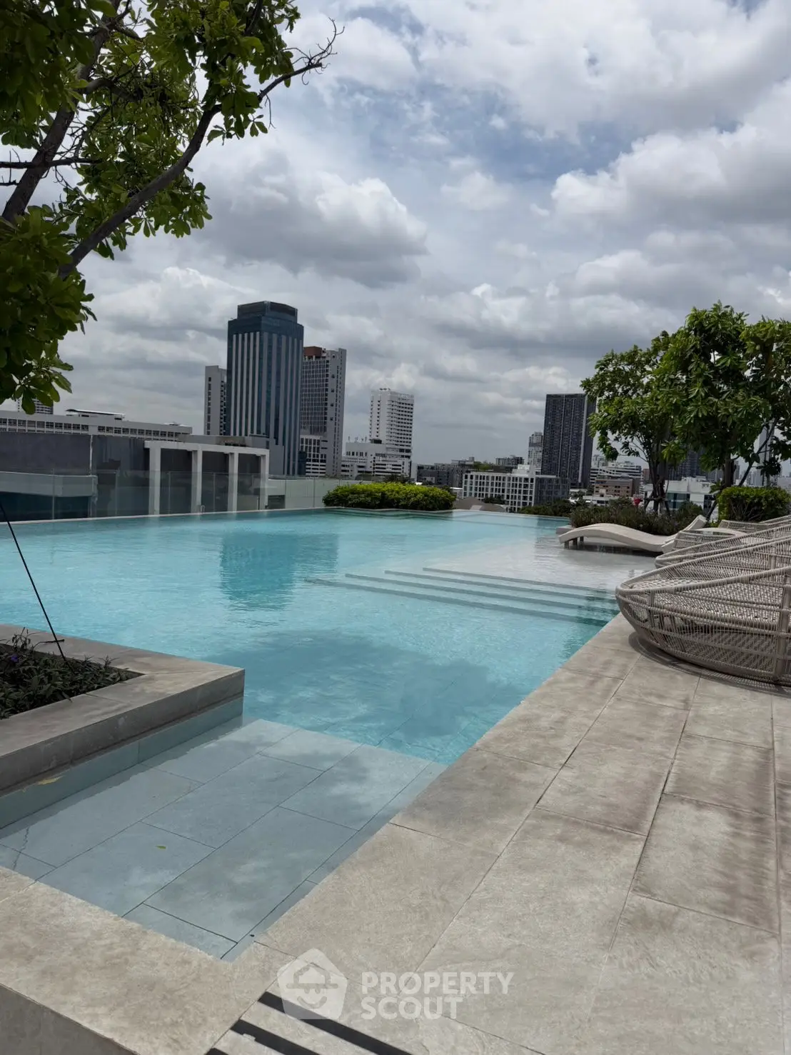 Luxurious rooftop infinity pool with stunning city skyline views, perfect for relaxation and leisure.