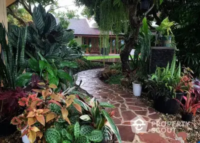 Charming garden pathway leading to a cozy home surrounded by lush greenery and vibrant plants.