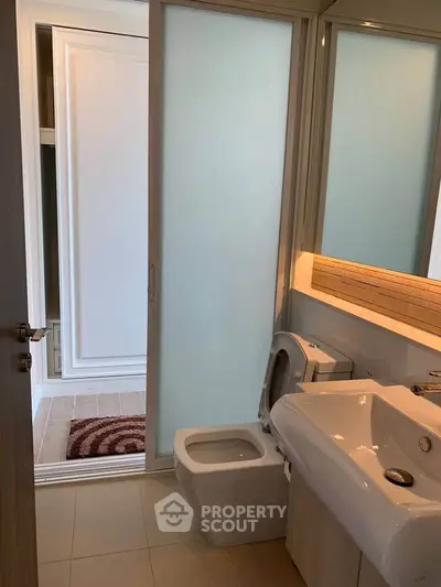 Modern bathroom with sleek fixtures and frosted glass door
