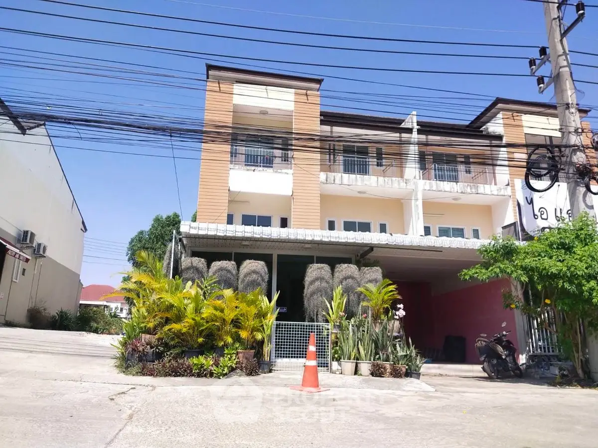 Modern townhouse exterior with lush landscaping and clear blue sky.