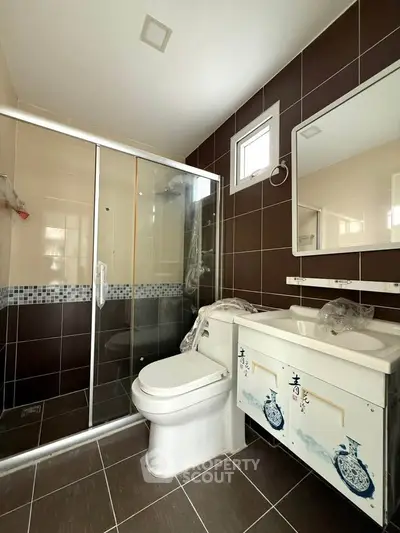 Modern bathroom with glass shower and stylish vanity in a contemporary home.