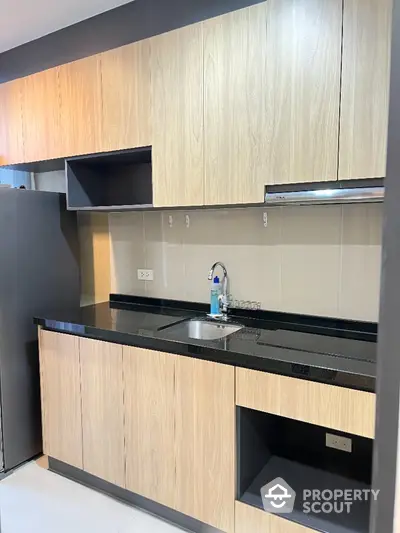 Modern kitchen with sleek wooden cabinets and black countertop