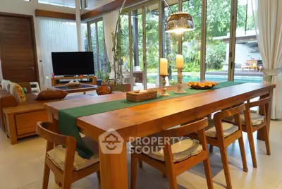 Spacious living room with wooden dining set and pool view, perfect for modern family gatherings.