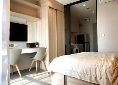 Modern bedroom with study area and sleek furniture in a bright apartment.