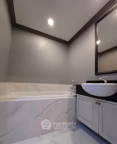 Elegant bathroom with marble bathtub and modern sink in luxury home.