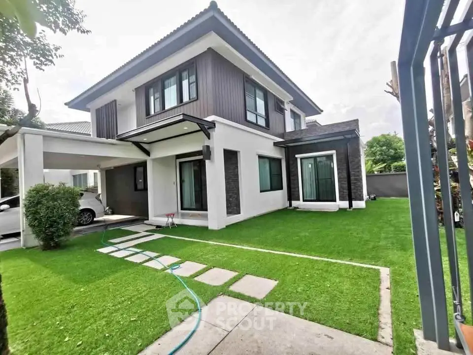 Modern two-story house with manicured lawn and carport in a serene neighborhood.