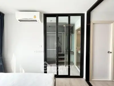 Modern bedroom with sliding glass doors and air conditioning in a stylish apartment.