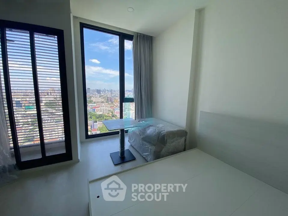 Modern bedroom with floor-to-ceiling windows offering stunning city views