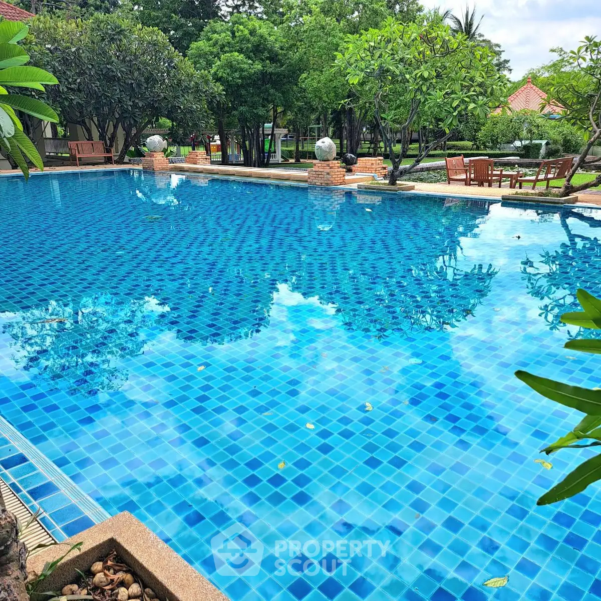 Stunning outdoor pool surrounded by lush greenery in a serene residential setting.