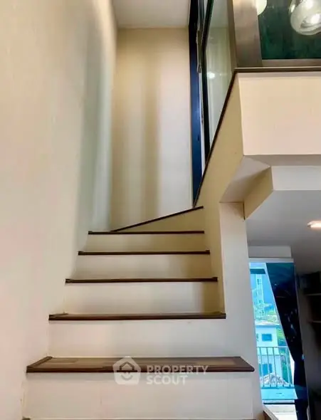 Modern interior staircase with sleek design and glass railing in a contemporary home.
