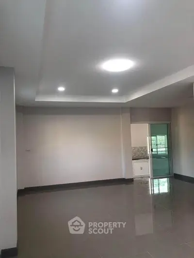 Spacious modern living room with sleek flooring and recessed lighting, perfect for contemporary living.
