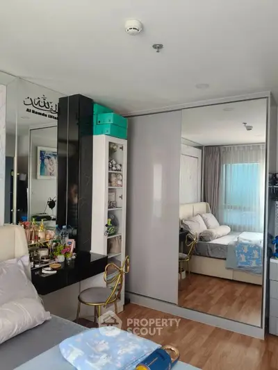 Chic bedroom with mirrored wardrobe and elegant decor, featuring a cozy bed and stylish vanity area.