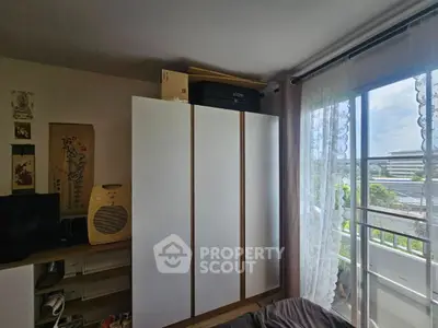 Cozy bedroom with wardrobe and balcony view, perfect for urban living.