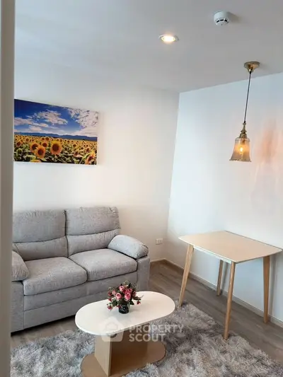 Cozy living room with modern decor, featuring a plush sofa, stylish table, and vibrant sunflower artwork.