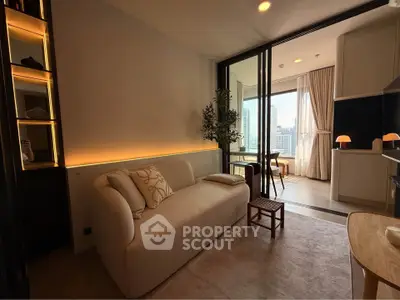 Modern living room with cozy sofa and city view, open layout to kitchen area.