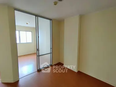 Spacious interior with sliding glass door and wooden flooring, perfect for modern living.