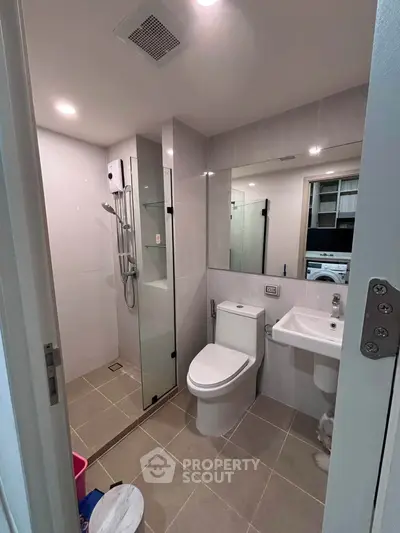 Modern bathroom with glass shower and sleek fixtures in a contemporary apartment.