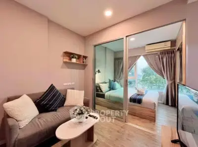 Modern living room with cozy sofa and view into stylish bedroom, featuring elegant decor and natural light.