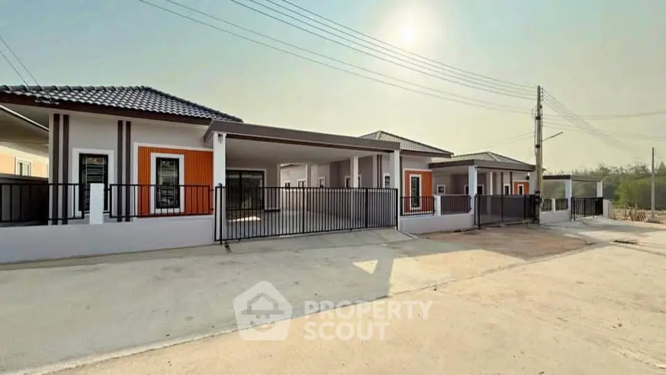 Modern single-story house with gated driveway and contemporary design.