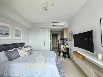 Modern bedroom with stylish decor and open layout leading to kitchen area.