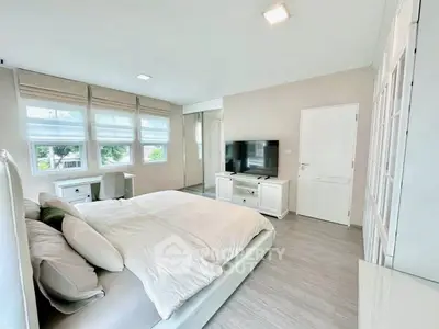 Spacious modern bedroom with large windows and stylish decor