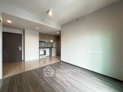 Modern open-plan living room with sleek kitchen in a contemporary apartment.